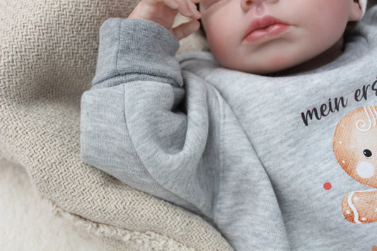 Weihnachtsoutfit für Babys und Kleinkinder. Das Set besteht aus einem oversized geschnittenen Sweater mit wunderschönem Lebkuchen Print und einer weihnachtlichen Hose.