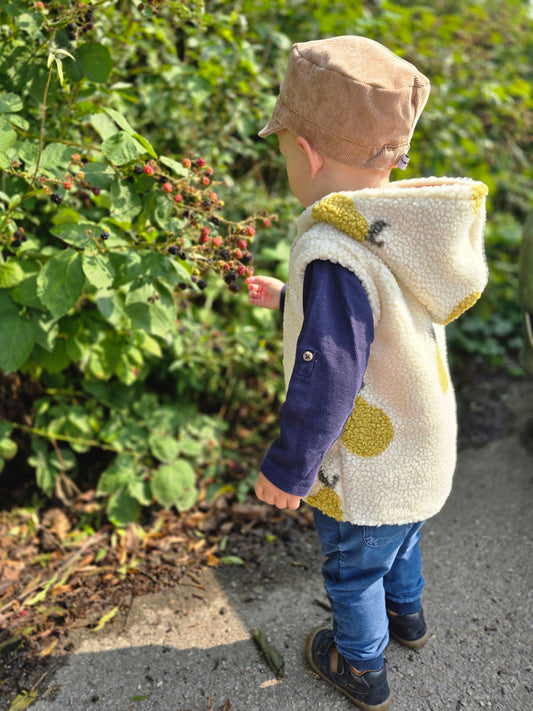 Weste aus einem flauschigem Teddystoff nach Wahl mit Kapuze und Reißverschluss. Gefüttert mit einem beigen Innenfutter.