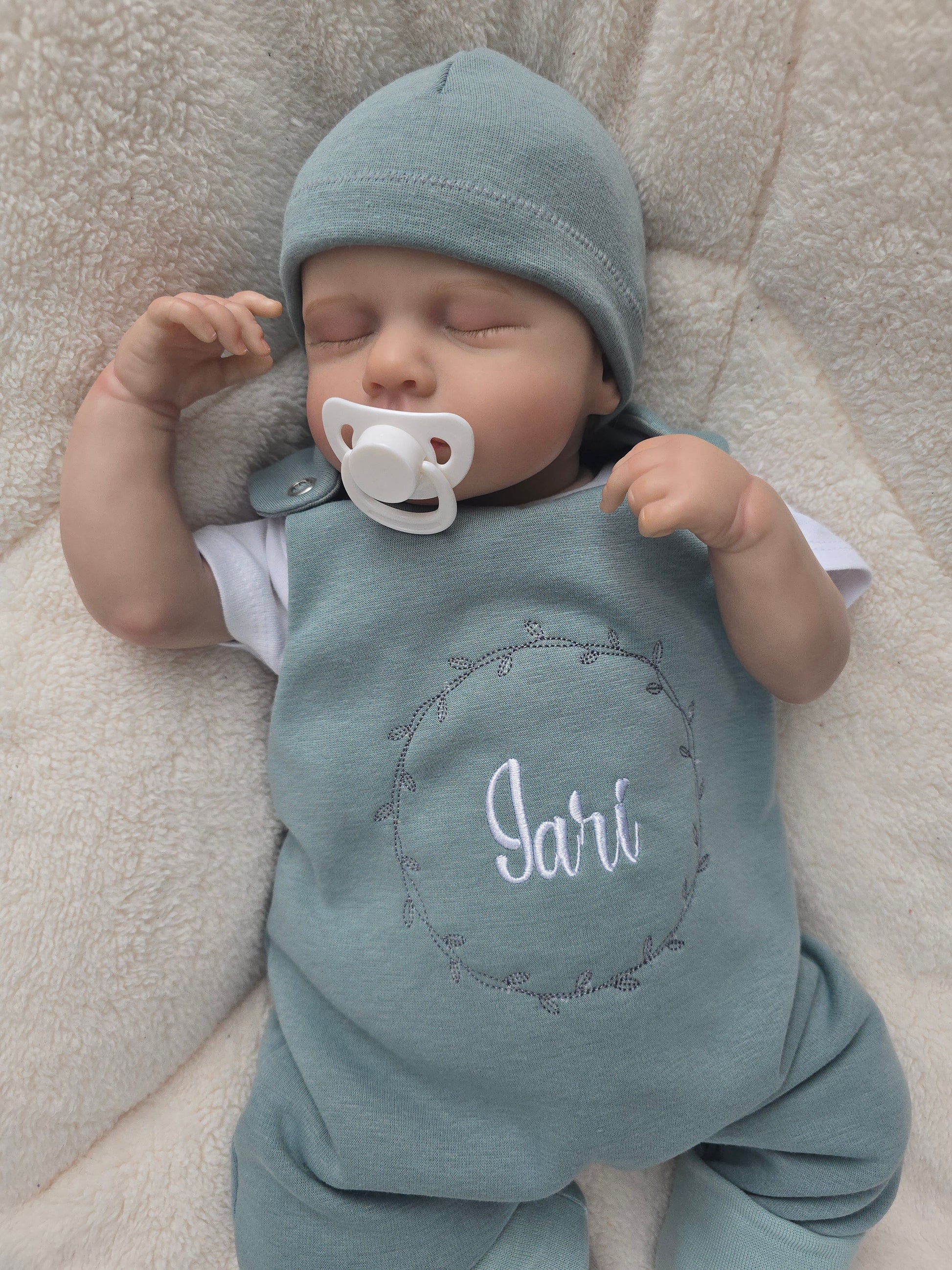Baby Strampler gefüttert aus Sweat mit individueller Stickerei auf dem Vorderteil. Inklusive dazu passender Mütze aus Sweat.