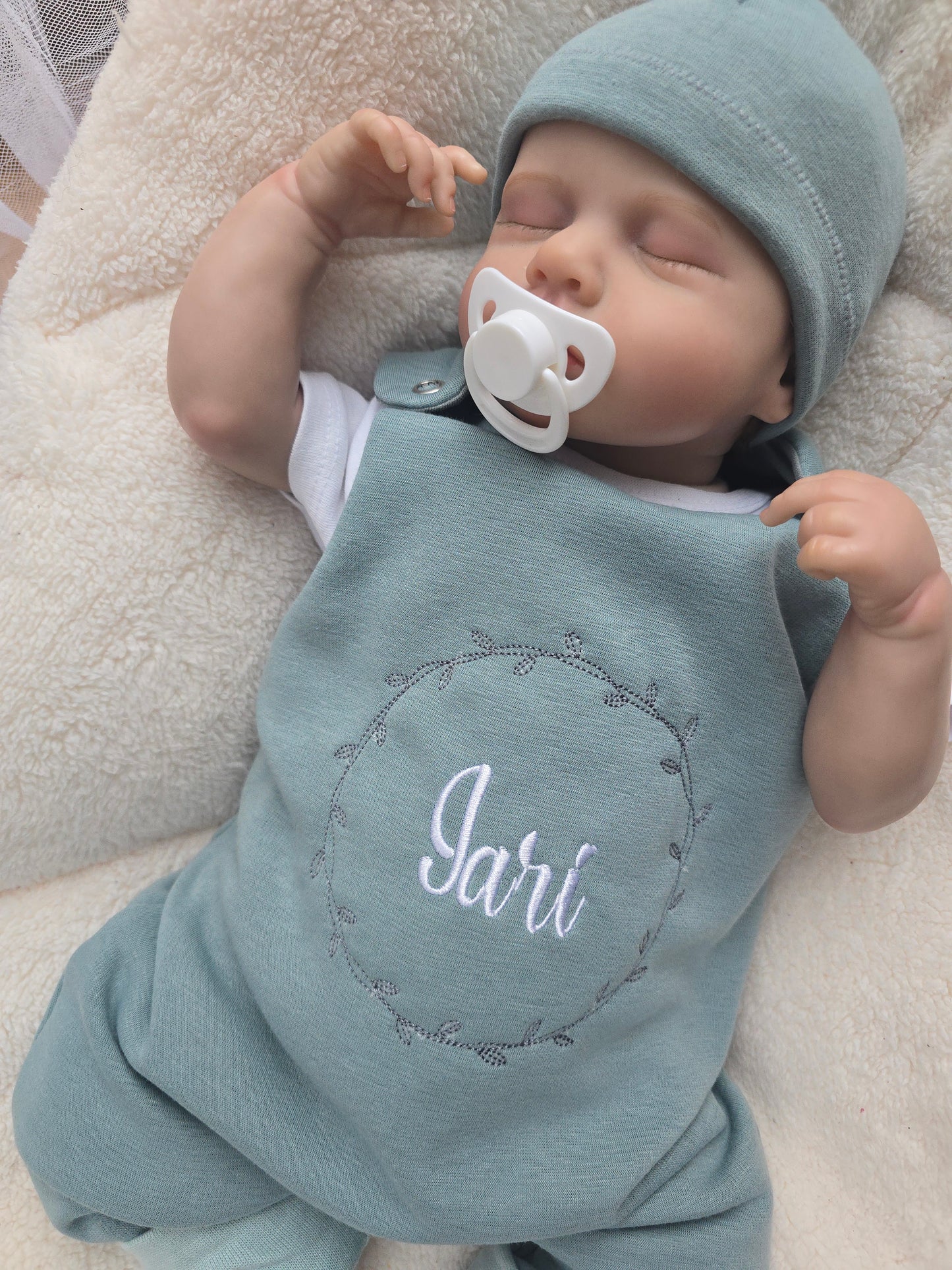 Baby Strampler gefüttert aus Sweat mit individueller Stickerei auf dem Vorderteil. Inklusive dazu passender Mütze aus Sweat.