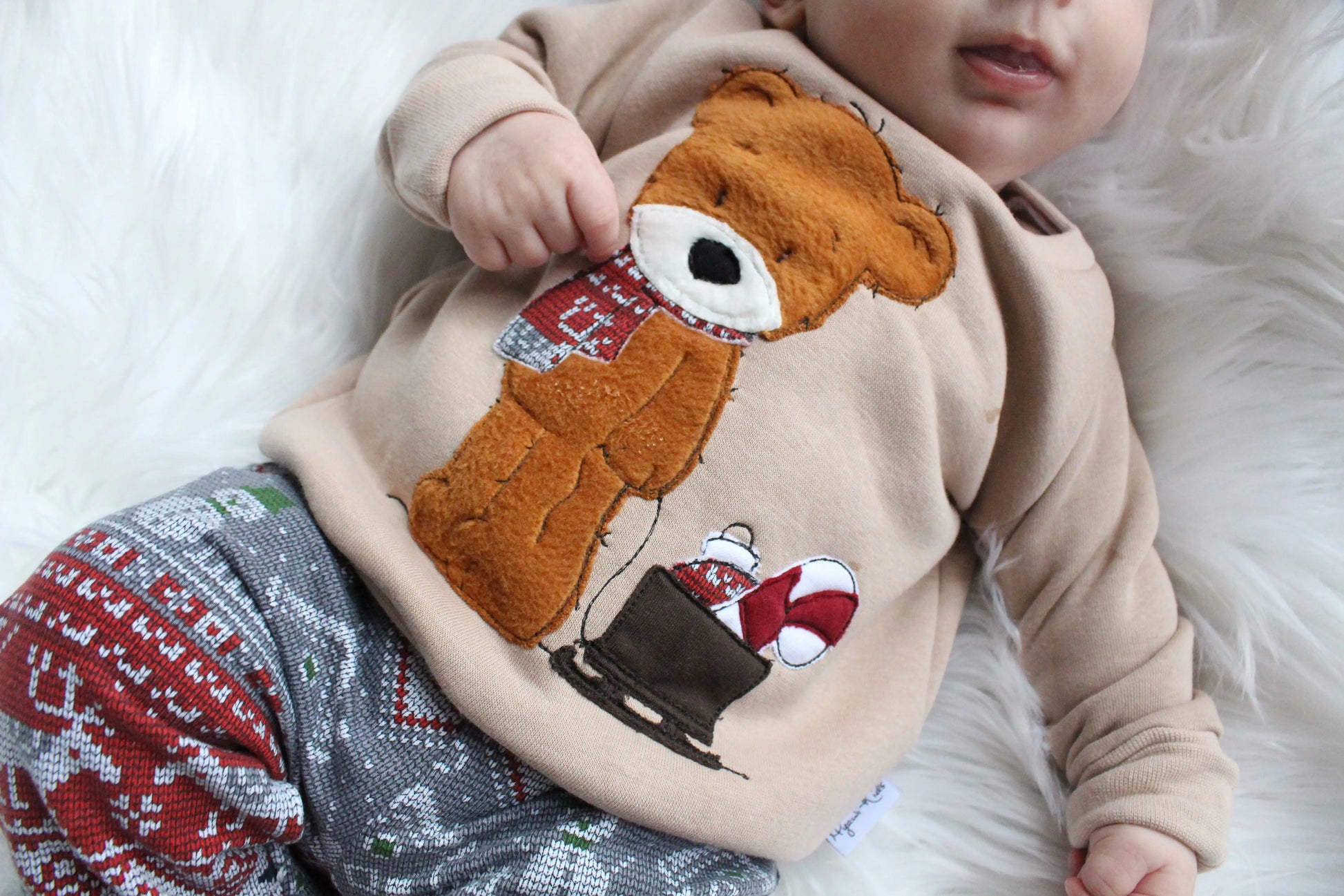 Weihnachtsoutfit für Babys und Kleinkinder. Das Set besteht aus einem oversized geschnittenen Sweater mit wunderschöner Applikation und einer weihnachtlichen Hose. 